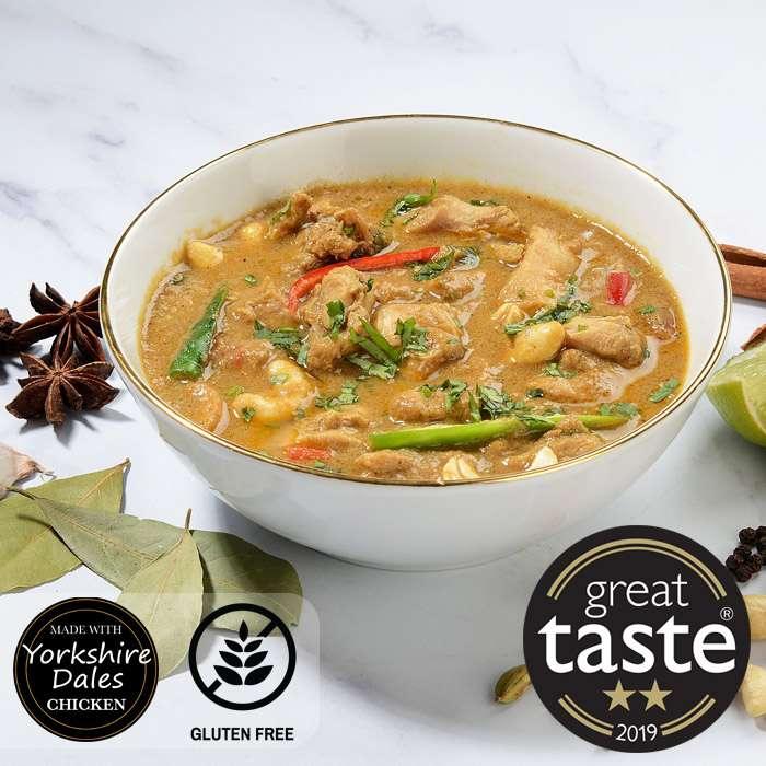 Creamy chicken curry with chickpeas, green beans, and red peppers in white bowl
