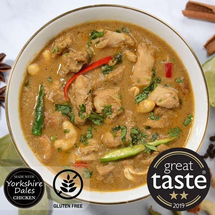Chicken curry with chickpeas, green beans, and red chili in white bowl