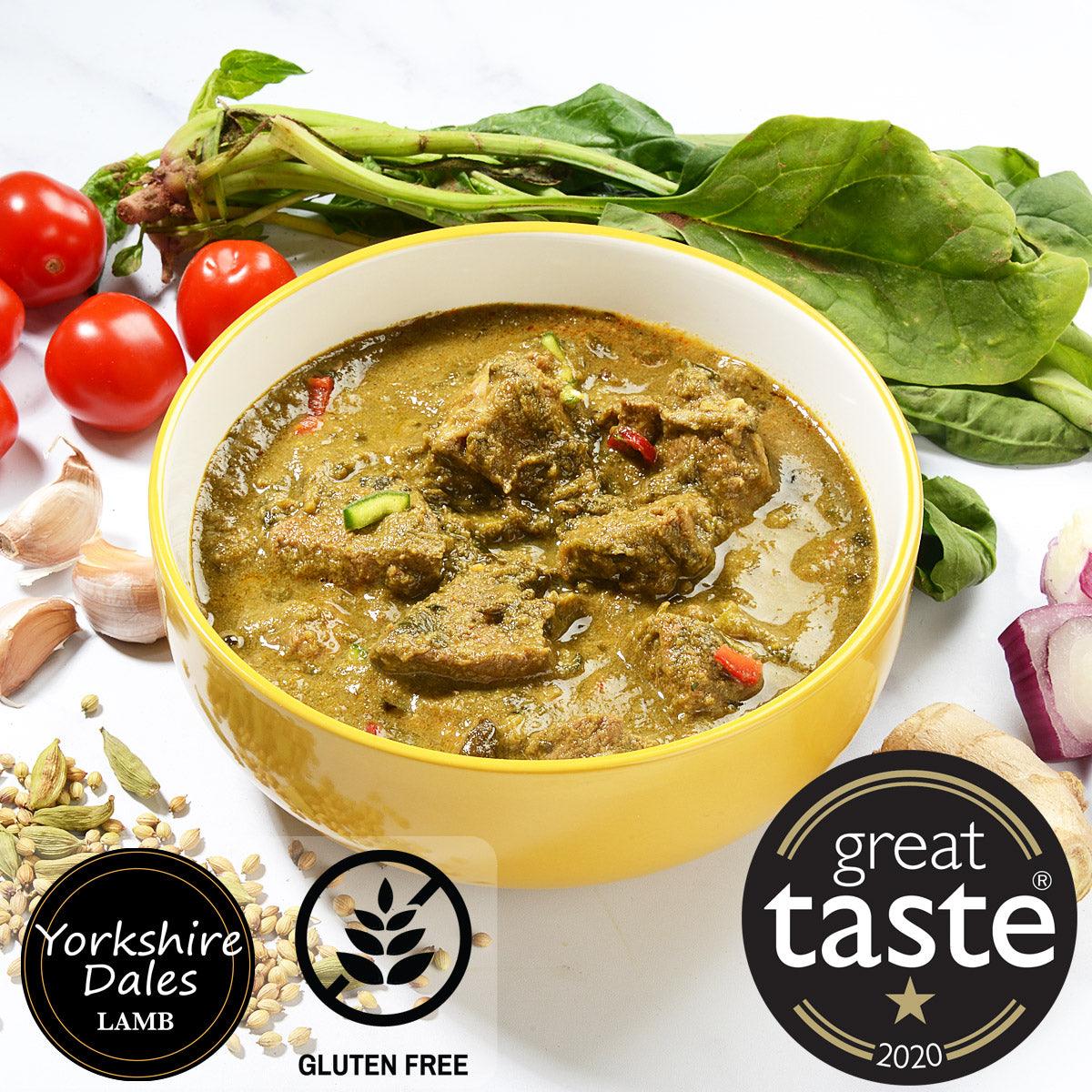 Golden lamb curry with green chili in white and yellow bowl, fresh vegetables and nuts displayed around it