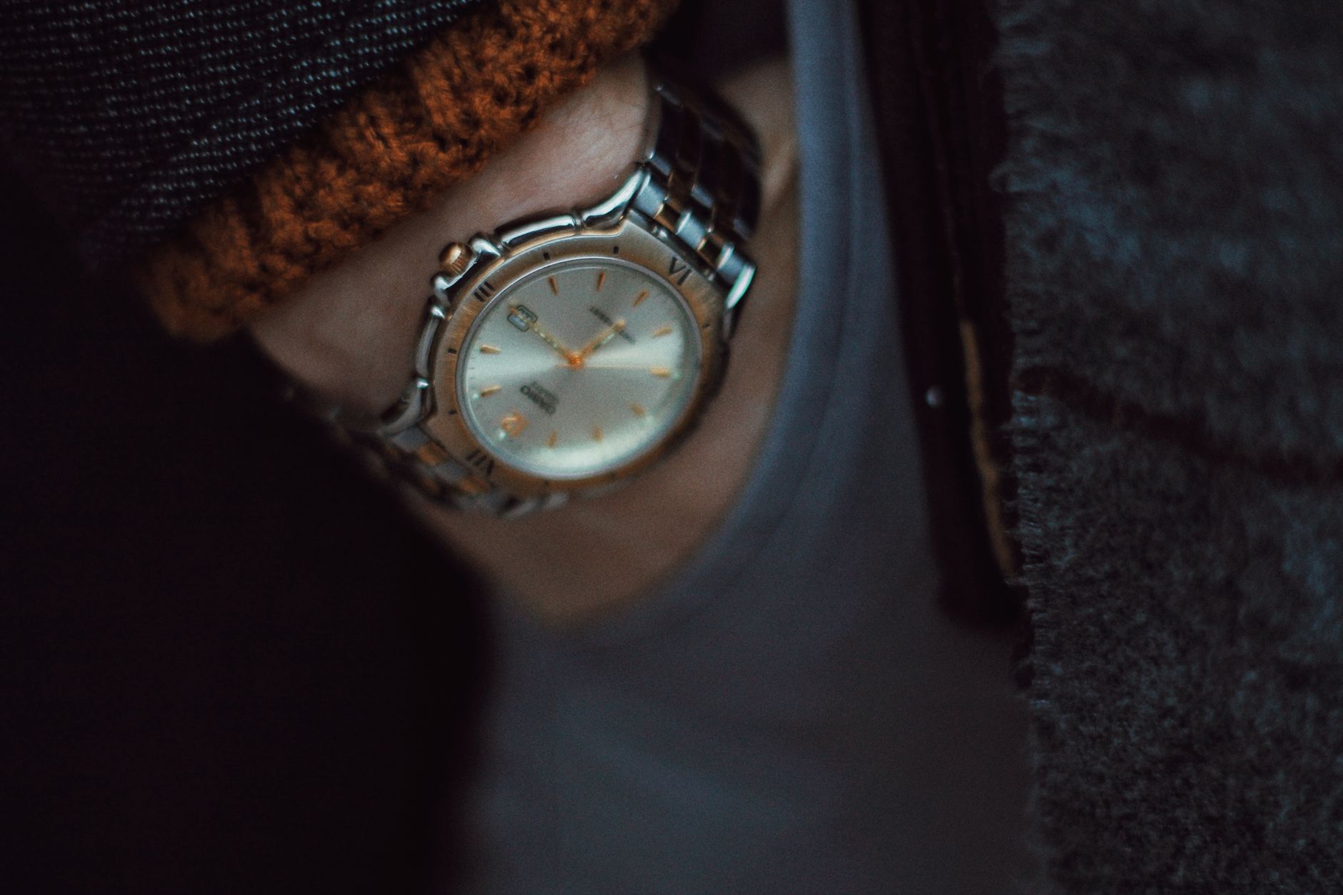 Stainless steel watch with mixed metal band and rose gold accents on person's wrist